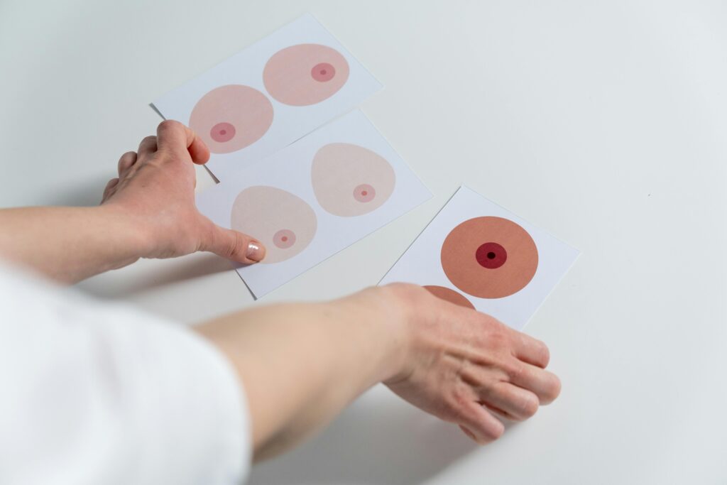 Image of hands arranging breast anatomy illustrations for awareness and education.
